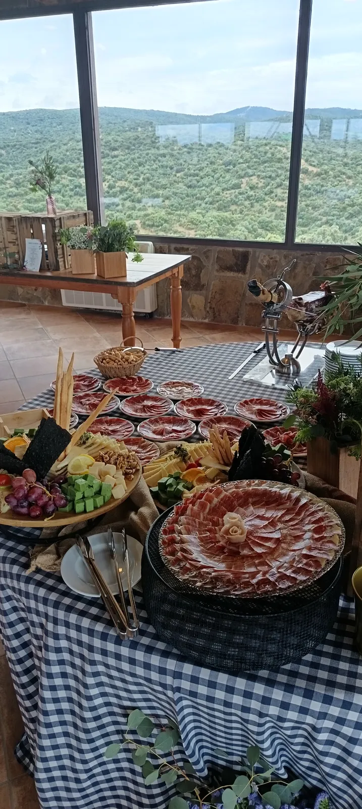 Mesa gourmet de jamón y quesos con vistas a la sierra